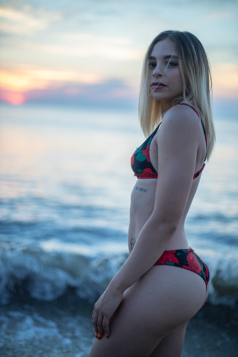 woman in red bikini bottom standing on beach during sunset