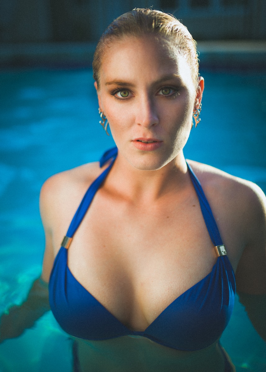 woman in blue string bikini top in pool looking straight