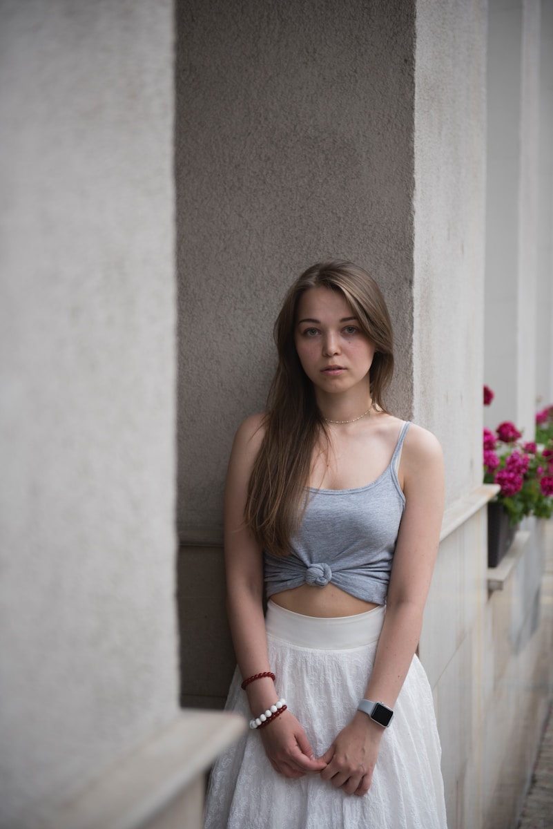 selective focus photography of woman wearing crop top leaning on wall