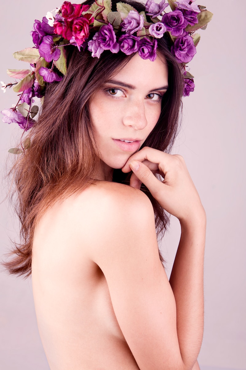 topless woman with purple flower on her head